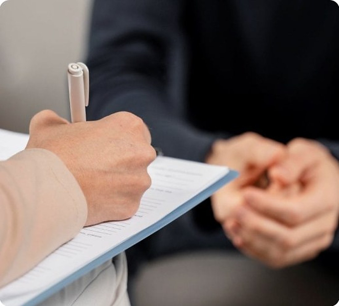 A Care Hub coordinator taking notes with a participant during an NDIS planning conversation at home